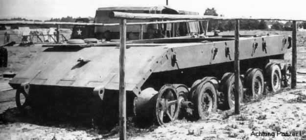 Sort-hvidt foto fra 1945 af det ufærdige E-100-chassis bag et hegn