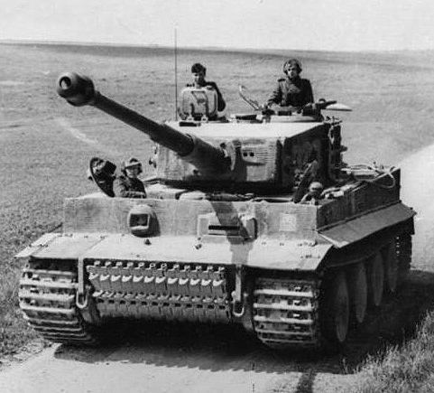 Sort-hvidt foto af en Tiger I med besætning i tårnet, kørende på en mark i Nordfrankrig